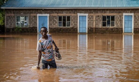 Joseph Kamau crosses a flooded area on the way to his home in Garissa on November 21, 2023.