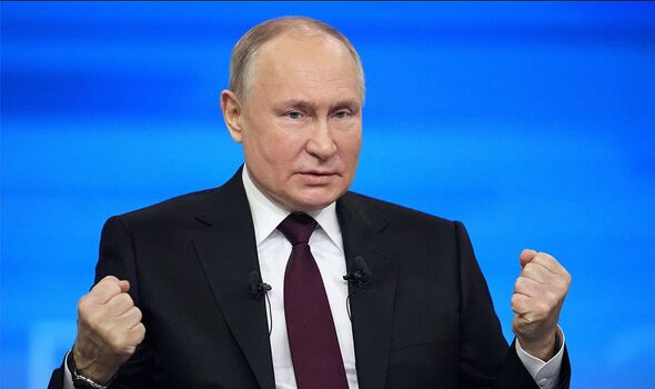 Vladimir Putin bears his fists in an aggressive stance during press conference